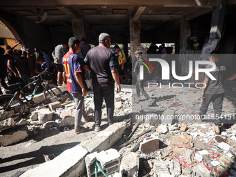 Palestinians inspect a school that the Israeli occupation army attacks in Deir al-Balah, Gaza, on October 10, 2024. The Israeli army attacks...