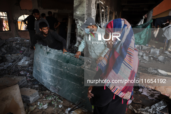 Palestinians inspect a school that the Israeli occupation army attacks in Deir al-Balah, Gaza, on October 10, 2024. The Israeli army attacks...