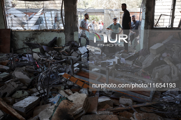 Palestinians inspect a school that the Israeli occupation army attacks in Deir al-Balah, Gaza, on October 10, 2024. The Israeli army attacks...