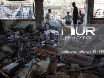 Palestinians inspect a school that the Israeli occupation army attacks in Deir al-Balah, Gaza, on October 10, 2024. The Israeli army attacks...