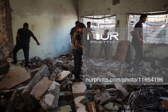 Palestinians inspect a school that the Israeli occupation army attacks in Deir al-Balah, Gaza, on October 10, 2024. The Israeli army attacks...