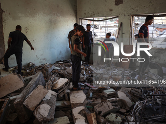 Palestinians inspect a school that the Israeli occupation army attacks in Deir al-Balah, Gaza, on October 10, 2024. The Israeli army attacks...