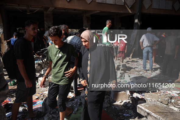 Palestinians inspect a school that the Israeli occupation army attacks in Deir al-Balah, Gaza, on October 10, 2024. The Israeli army attacks...