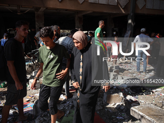 Palestinians inspect a school that the Israeli occupation army attacks in Deir al-Balah, Gaza, on October 10, 2024. The Israeli army attacks...