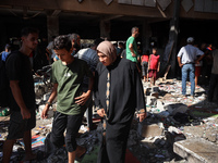 Palestinians inspect a school that the Israeli occupation army attacks in Deir al-Balah, Gaza, on October 10, 2024. The Israeli army attacks...