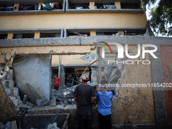 Palestinians inspect a school that the Israeli occupation army attacks in Deir al-Balah, Gaza, on October 10, 2024. The Israeli army attacks...