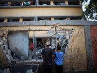 Palestinians inspect a school that the Israeli occupation army attacks in Deir al-Balah, Gaza, on October 10, 2024. The Israeli army attacks...