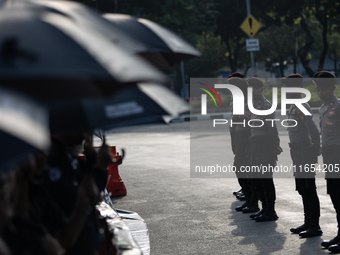 Police stand guard during the 835th Aksi Kamisan, or Thursday's Protest, in front of the Presidential Palace in Jakarta, Indonesia, on Octob...