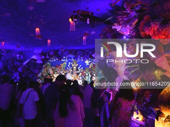 Devotees throng at a community 'puja pandal' themed on 'under the sea' during the Durga Puja festival in the Nagaon district of Assam, India...