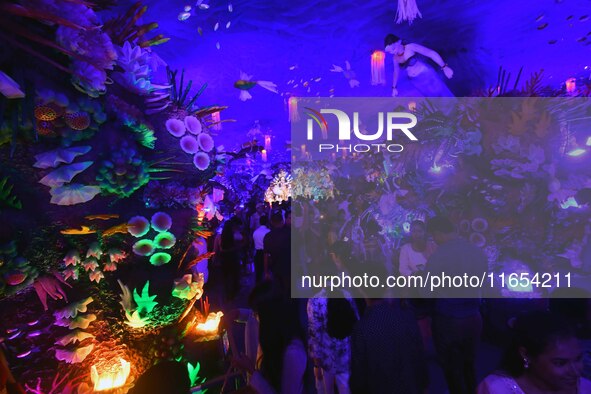 Devotees throng at a community 'puja pandal' themed on 'under the sea' during the Durga Puja festival in the Nagaon district of Assam, India...