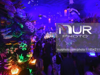 Devotees throng at a community 'puja pandal' themed on 'under the sea' during the Durga Puja festival in the Nagaon district of Assam, India...