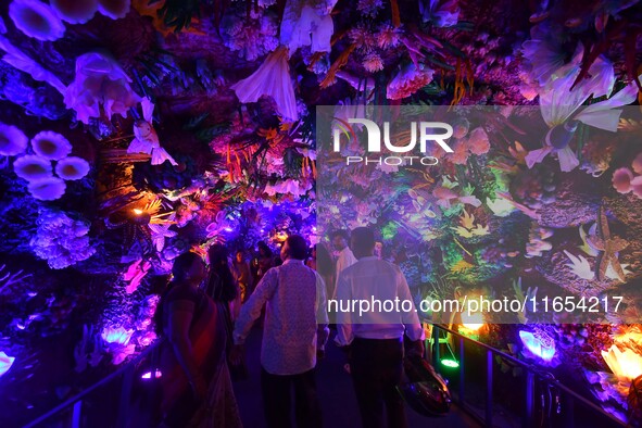 Devotees throng at a community 'puja pandal' themed on 'under the sea' during the Durga Puja festival in the Nagaon district of Assam, India...