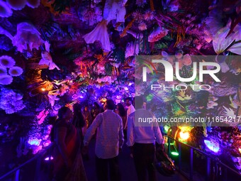 Devotees throng at a community 'puja pandal' themed on 'under the sea' during the Durga Puja festival in the Nagaon district of Assam, India...