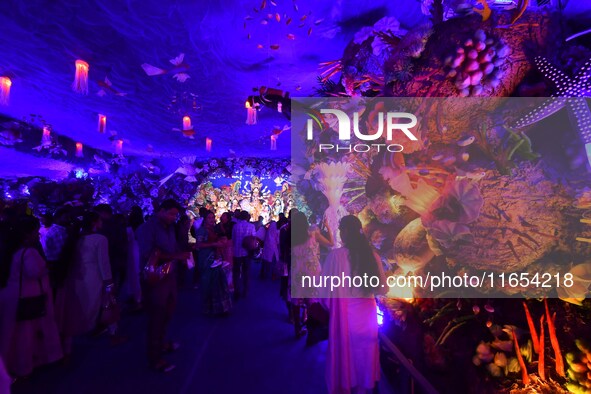 Devotees throng at a community 'puja pandal' themed on 'under the sea' during the Durga Puja festival in the Nagaon district of Assam, India...