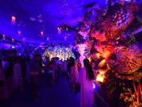 Devotees throng at a community 'puja pandal' themed on 'under the sea' during the Durga Puja festival in the Nagaon district of Assam, India...