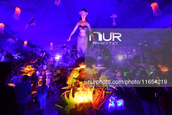 Devotees throng at a community 'puja pandal' themed on 'under the sea' during the Durga Puja festival in the Nagaon district of Assam, India...