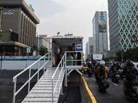 People are at a bus stop in the business district of Jakarta, Indonesia, on October 10, 2024. According to the Expert Council of the Nationa...