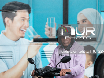 Motorcyclists pass through the business district of Jakarta, Indonesia, on October 10, 2024. According to the Expert Council of the National...