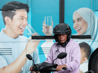 Motorcyclists pass through the business district of Jakarta, Indonesia, on October 10, 2024. According to the Expert Council of the National...