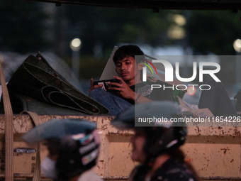 A passenger in a truck passes through the business district of Jakarta, Indonesia, on October 10, 2024. According to the Expert Council of t...