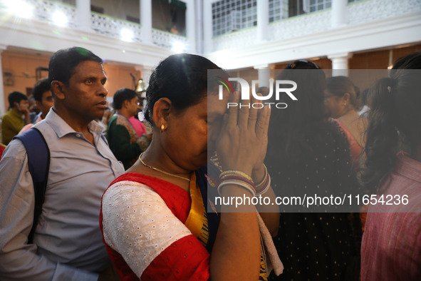 A woman offers prayer at a heritage house during the Durga Puja festival in Kolkata, India, on October 10, 2024. The annual Durga Puja festi...