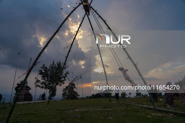 People play on a traditional bamboo swing during the Dashain festival in the outskirts of Kathmandu, Nepal, on October 10, 2024. 