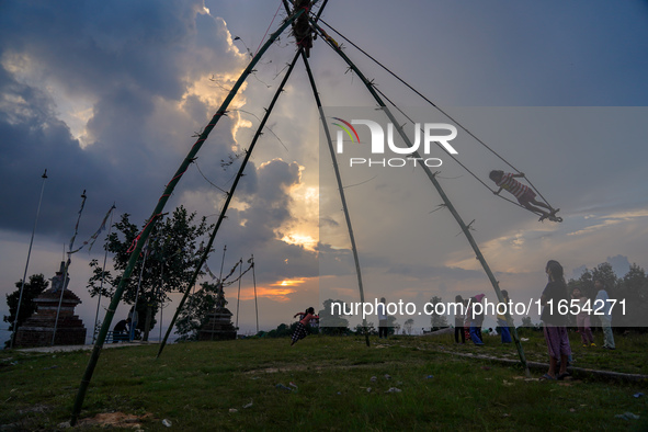 People play on a traditional bamboo swing during the Dashain festival in the outskirts of Kathmandu, Nepal, on October 10, 2024. 