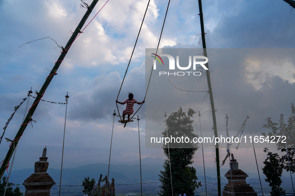 People play on a traditional bamboo swing during the Dashain festival in the outskirts of Kathmandu, Nepal, on October 10, 2024. 