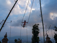 People play on a traditional bamboo swing during the Dashain festival in the outskirts of Kathmandu, Nepal, on October 10, 2024. (