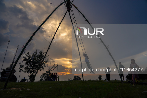 People play on a traditional bamboo swing during the Dashain festival in the outskirts of Kathmandu, Nepal, on October 10, 2024. 