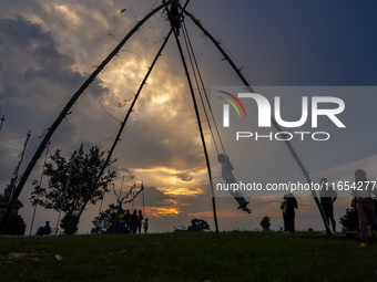 People play on a traditional bamboo swing during the Dashain festival in the outskirts of Kathmandu, Nepal, on October 10, 2024. (