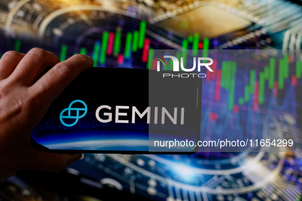 In this photo illustration, the Gemini logo is seen displayed on a smartphone screen against a computer screen displaying a stock market gra...