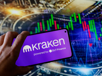 In this photo illustration, the Kraken logo is seen displayed on a smartphone screen against a computer screen displaying a stock market gra...