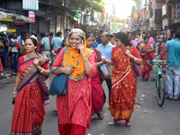 A woman talks on her mobile while walking inside a market in Kolkata, India, on October 10, 2024. (