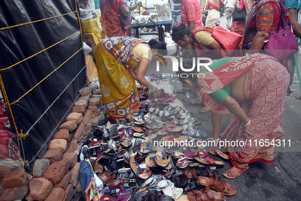 A woman sells shoes inside a market in Kolkata, India, on October 10, 2024. 