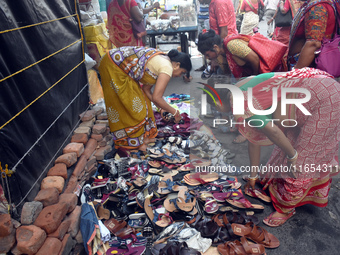 A woman sells shoes inside a market in Kolkata, India, on October 10, 2024. (