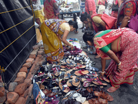 A woman sells shoes inside a market in Kolkata, India, on October 10, 2024. (