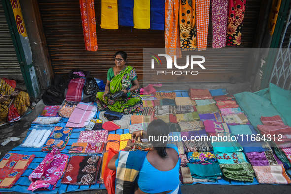 A woman sells garments inside a market in Kolkata, India, on October 10, 2024. 