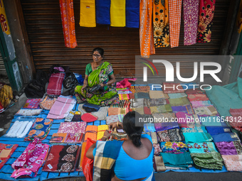 A woman sells garments inside a market in Kolkata, India, on October 10, 2024. (