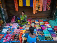 A woman sells garments inside a market in Kolkata, India, on October 10, 2024. (