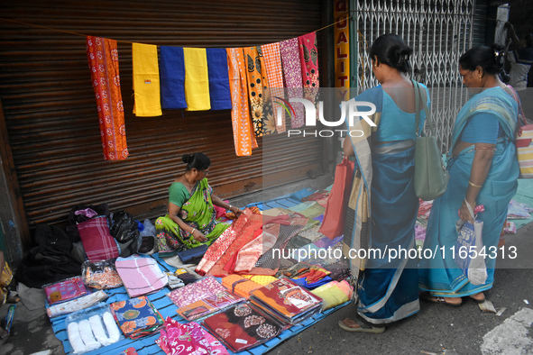 A woman sells garments inside a market in Kolkata, India, on October 10, 2024. 