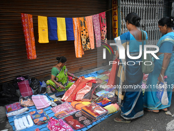 A woman sells garments inside a market in Kolkata, India, on October 10, 2024. (