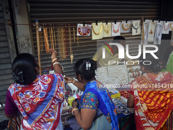 Women buy imitation jewelry on the occasion of the Durga Puja festival from a roadside shop inside a market in Kolkata, India, on October 10...