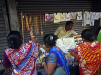 Women buy imitation jewelry on the occasion of the Durga Puja festival from a roadside shop inside a market in Kolkata, India, on October 10...