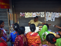 Women buy imitation jewelry on the occasion of the Durga Puja festival from a roadside shop inside a market in Kolkata, India, on October 10...