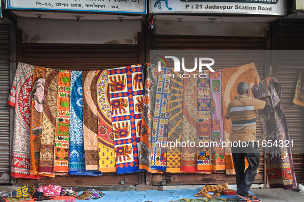 A person displays bedsheets at a roadside shop in Kolkata, India, on October 10, 2024. 