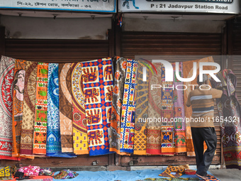 A person displays bedsheets at a roadside shop in Kolkata, India, on October 10, 2024. (