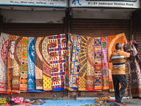 A person displays bedsheets at a roadside shop in Kolkata, India, on October 10, 2024. (