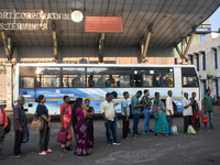 People stand in a queue inside a bus stand to pick up a bus in Kolkata, India, on October 10, 2024. (