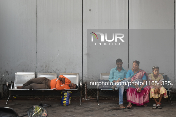 A food delivery person sleeps inside a bus stand in Kolkata, India, on October 10, 2024. 